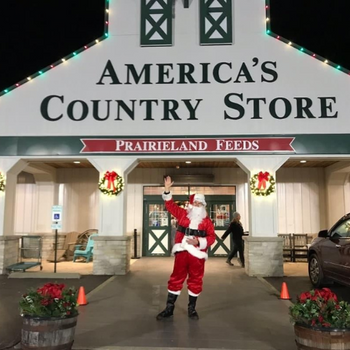 Prairieland store front decorated for the holidays with Santa standing in front