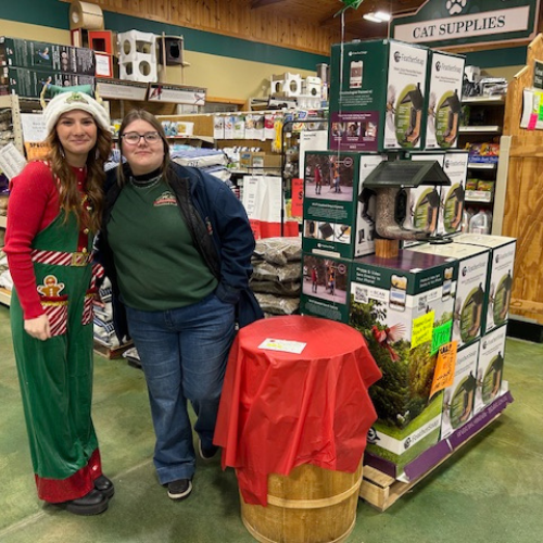 Prairieland Feed staff in front of Christmas supplies