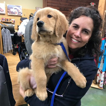 Prairieland staff holding a golden retriever puppy